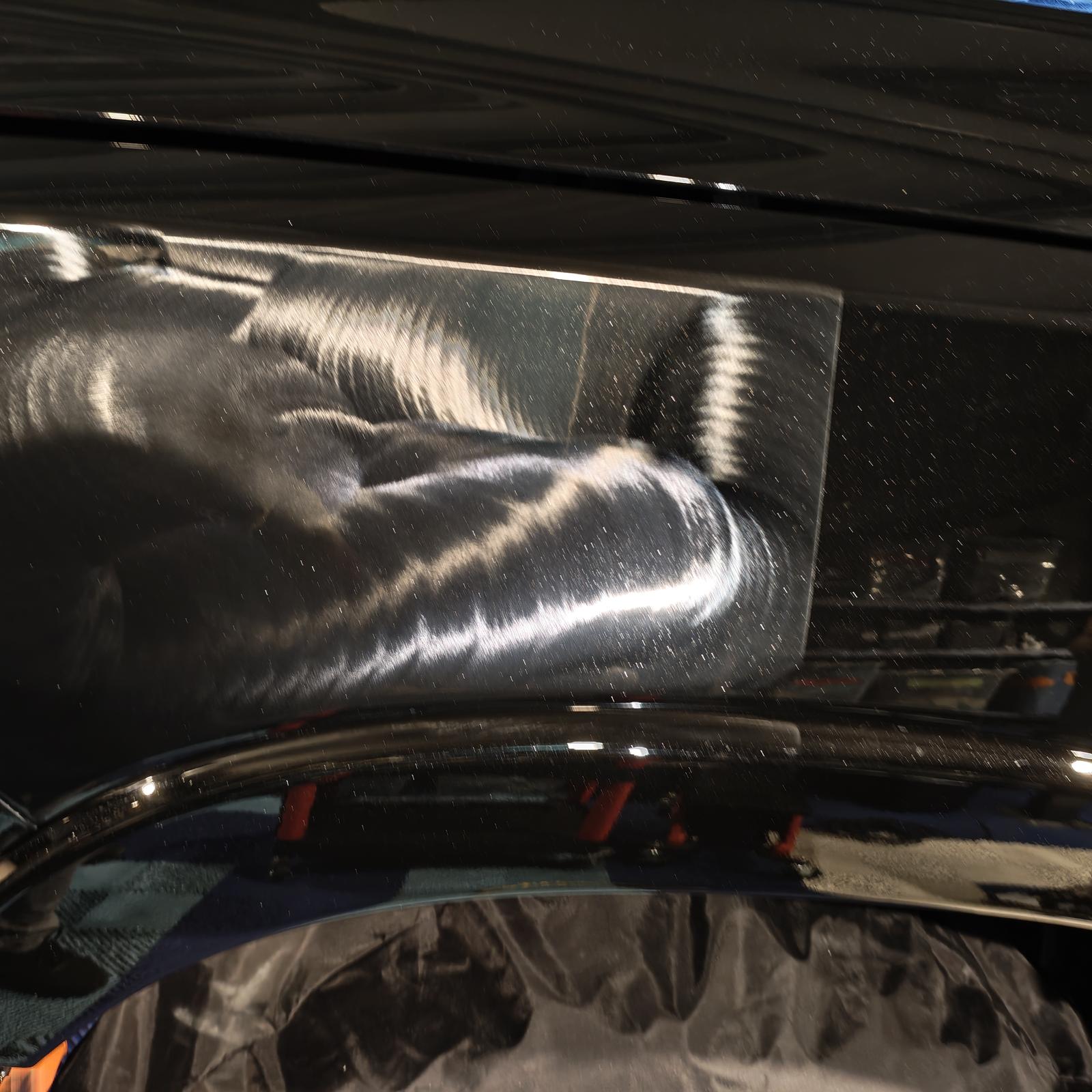Reflet brillant sur carrosserie noire après polissage et lustrage professionnel